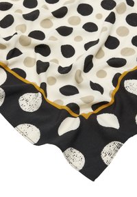 Czarnobiała tkanina w groszki z beżowymi kółkami, z falbanką na krawędzi i złotą linią ozdobną. Miękka w dotyku, lekka w konstrukcji.