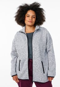 Gray, zippered fleece jacket with black accents, featuring side pockets and a high collar; lightweight, textured fabric.