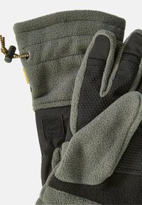 Fleece gloves in dark green with a padded wrist, black silicone grip on fingers, and an adjustable cord for a snug fit.