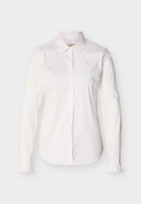 Λευκό γυναικείο πουκάμισο με μακριά μανίκια, μυτερό γιακά, κρυφά κουμπιά μπροστά και μικρές βολάν λεπτομέρειες στις μανσέτες.