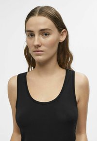 Sort ærmeløs tanktop lavet af glat, strækbart stof med en rund halsudskæring. Har et minimalistisk design og en tætsiddende silhuet.