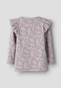 Haut à manches longues en tissu côtelé doux, rose pâle avec un motif floral bleu et vert ; présente des épaules à volants et un col rond.
