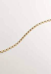 Collar de cadena de oro con eslabones ovalados, una textura suave y brillante, y un diseño minimalista, sobre un fondo neutro.