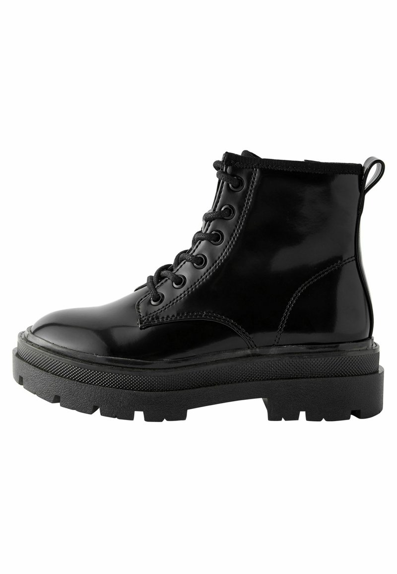 Bottines en cuir verni noir avec une semelle en caoutchouc texturée épaisse, bout rond et un laçage à six œillets avec une languette.