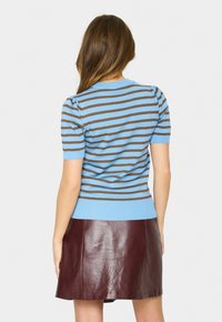 Blue and brown striped short-sleeve sweater with a ribbed neckline and hem, paired with a fitted burgundy leather skirt.