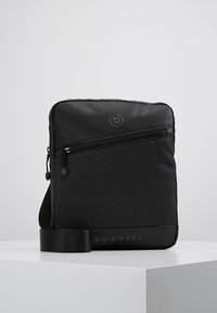 Borsa messaggera nera realizzata in pelle liscia e tessuto testurizzato, dotata di tasca frontale con zip, tracolla regolabile e dettaglio del logo.
