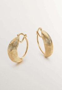Pendientes de aro de oro con una textura ondulada y acanalada. Su diseño incluye un cierre articulado para un ajuste seguro.