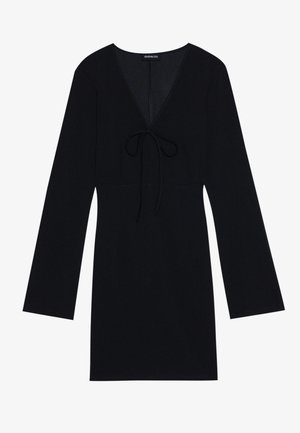 Black dress made of soft fabric, featuring a V-neck, long sleeves, and a tie detail at the front. Simple design, above-the-knee length.