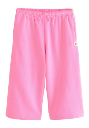 Różowe spodenki do kolan z elastycznym paskiem i sznurkiem, z małą beżową metką z ikoną tęczy po prawej stronie.