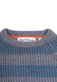 Stickad tröja i blå och grå ränder med en ribbad hals, med en orange inre krage och en etikett som säger "Band of Rascals."