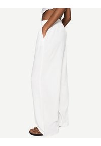 Bílé kalhoty s širokými nohavicemi vyrobené z lehkého materiálu, s elastickým pasem a bočními kapsami, které mají uvolněný střih a hladkou texturu.