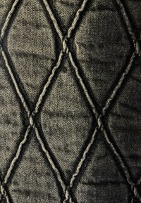 Tessuto trapuntato in grigio scuro, con un motivo a diamante e cuciture evidenti. La texture appare morbida con una superficie leggermente rialzata.