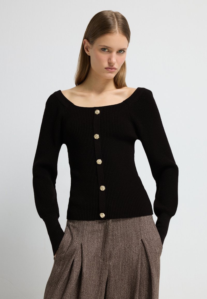 Schwarzer, gerippter Strickcardigan mit quadratischem Ausschnitt, ausgestattet mit sechs dekorativen goldenen Knöpfen auf der Vorderseite. Lange Ärmel und taillierte Passform.