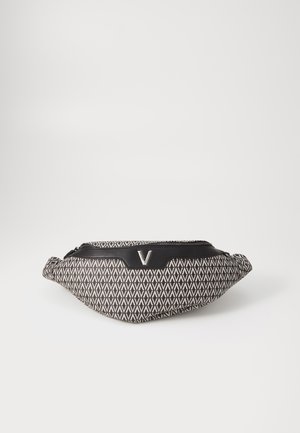 Juodos ir baltos spalvų raštuota krepšys ant klubų, su apvalia forma, tekstūruota medžiaga ir priekinė užtrauktuko kišenė su metaliniu logotipo akcentu.