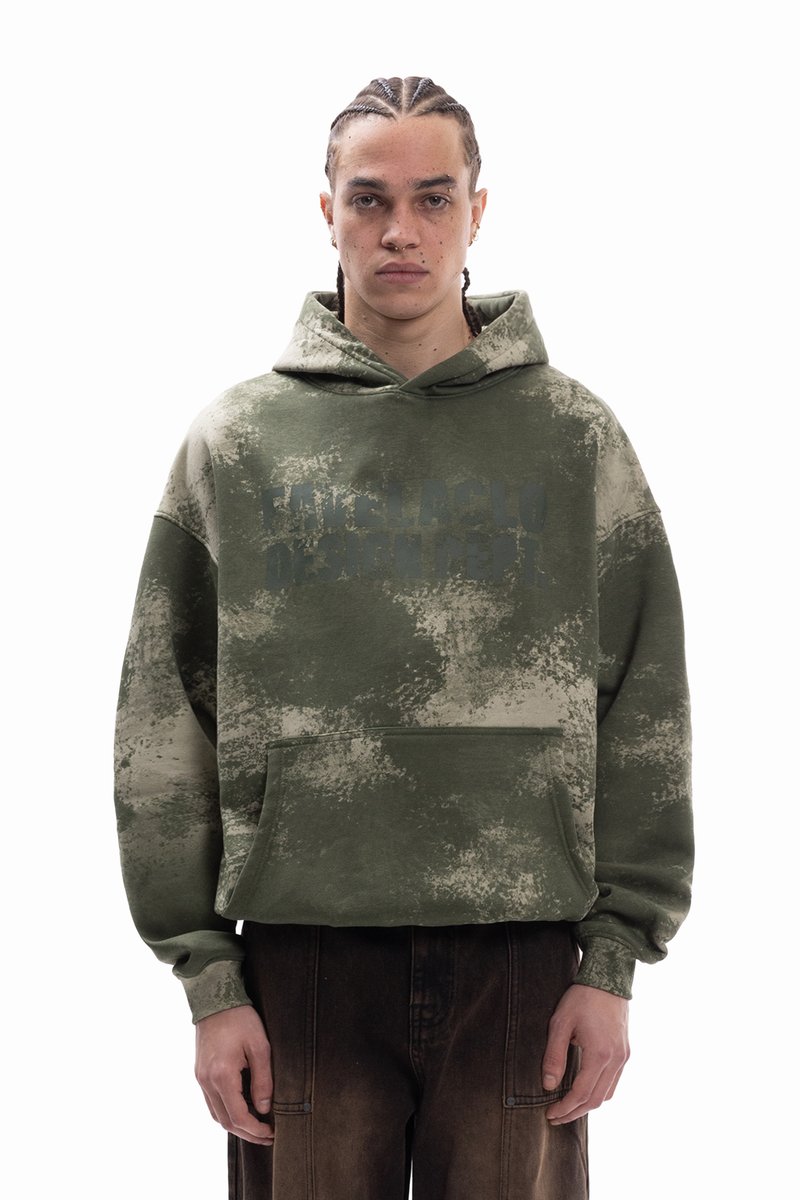 Zelen pulover s kapuco, prevelik, z teksturno vzorcem batik in sprednjim žepom. Na prsih ima nežno grafično tiskano podobo.