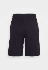 Svarta bomullsshorts med elastisk midja. Enkelt design, knälång med inga synliga mönster eller detaljer på baksidan.