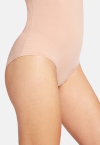 Body rosa chiaro con una texture liscia, vestibilità sagomata e copertura moderata. I lati senza cuciture e una leggera lucentezza arricchiscono il suo design.