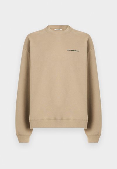 Μπεζ φούτερ με στρογγυλή λαιμόκοψη, μακριά μανίκια και μικρό λογότυπο "HOLZWEILER" στο αριστερό στήθος.