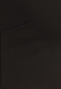 Tissu noir texturé, arborant un motif en nervures. Le matériau a une finition mate avec une apparence lisse et un design compact.