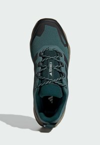 Ciemnoniebieskie buty outdoorowe z czarnymi akcentami, siateczkowa cholewka oraz skomplikowany system sznurowania. Lekka konstrukcja z wyściełaną wkładką dla komfortu.
