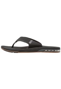 Zwarte flip-flop met een zachte rubberen band en een getextureerde voetbed. Versterkt met een luchtgeveerde zool voor comfort en ondersteuning.