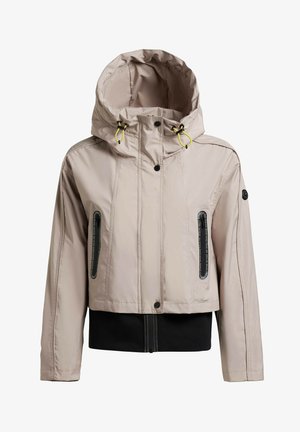 Bež jakna s kapuco rumenimi vrvicami, črnimi žepi z zadrgo, pritisnimi gumbi in črnim rebrastim pasom.