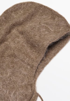 Primo piano di un morbido cappuccio in maglia marrone e peloso con un parziale cordoncino su uno sfondo bianco.