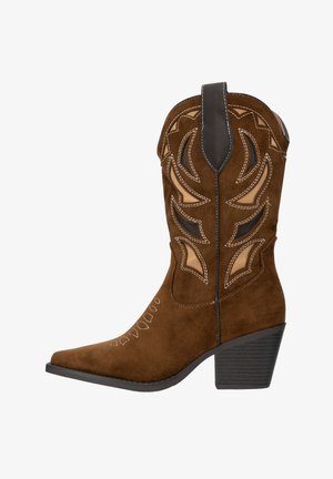Botte de cowboy en daim marron avec bout pointu, talon noir haut, découpes décoratives et surpiqûres contrastantes en beige. Détails complexes sur la tige.