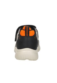 Zapatilla deportiva en negro y gris con acentos naranjas, que cuenta con una parte superior texturizada, suela acolchada y un cierre de correa seguro.