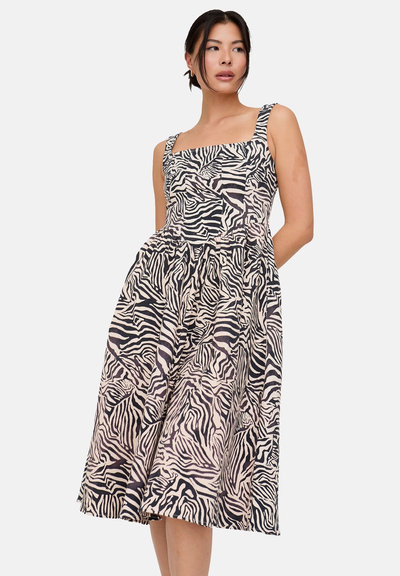 Zebra-Print-Kleid mit einem eckigen Ausschnitt, breiten Trägern und einem ausgestellten Rock. Der Stoff zeigt ein strukturiertes Muster in Schwarz und Beige.