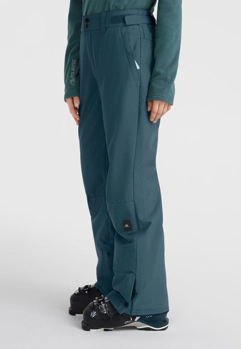 Ski broek in teal met een rechte snit, voorzien van een knoopband, zijzakken en een logopatch nabij de enkel. Gestructureerde, waterafstotende stof.