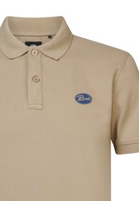 Beige poloko s krátkým rukávem, límcem, třemi knoflíky a modrým oválným logem. Vyrobeno z bavlny s texturovaným povrchem.