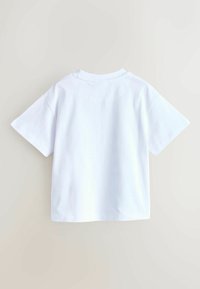 T-shirt blanc à manches courtes en coton. Présente un col rond classique, une coupe droite et des coutures nettes sans logos ni motifs visibles.