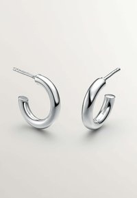 Pendientes de aro de plata con un diseño curvado y acabado pulido. Cada pendiente cuenta con un cierre de poste seguro para un uso fácil.