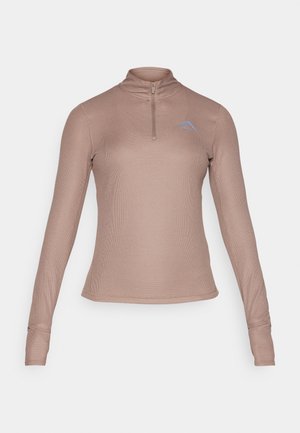 Hosszú ujjú, cipzáros nyakú felső világosbarna bordázott anyagból, finom kék logóval a mellrészen; testhez simuló fazon, hüvelyknyílásokkal a mandzsettákon.