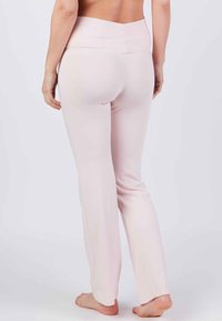 Helle rosa Fitnesshosen mit hohem Bund, weicher Textur und geradem Bein. Verfügt über ein nahtloses Design für zusätzlichen Komfort.