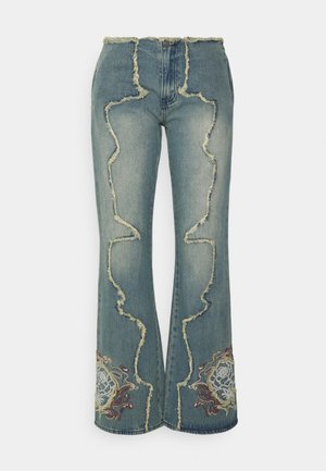 Denim jeans with flared legs, raw-edged wavy seams, and floral embroidery near the hem on both legs.