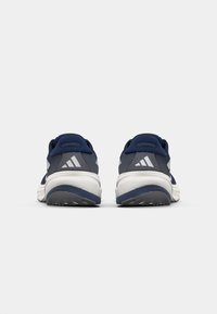 Marineblaue Sportschuhe mit grauem Mesh und weißen Akzenten. Verfügen über eine strukturierte Sohle und drei diagonale Streifen an den Seiten.