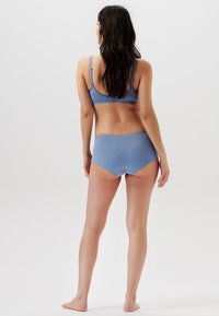 Blå bomullsbh och matchande högmidjade trosor, med en slät yta och subtil melerad mönstring. Justerbara axelremmar på bh:n.