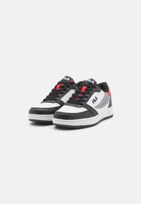 Zapatillas en negro, blanco y rojo con parte superior de cuero y sintético. Presenta una puntera redonda, cuello acolchado y suela de goma con tracción.