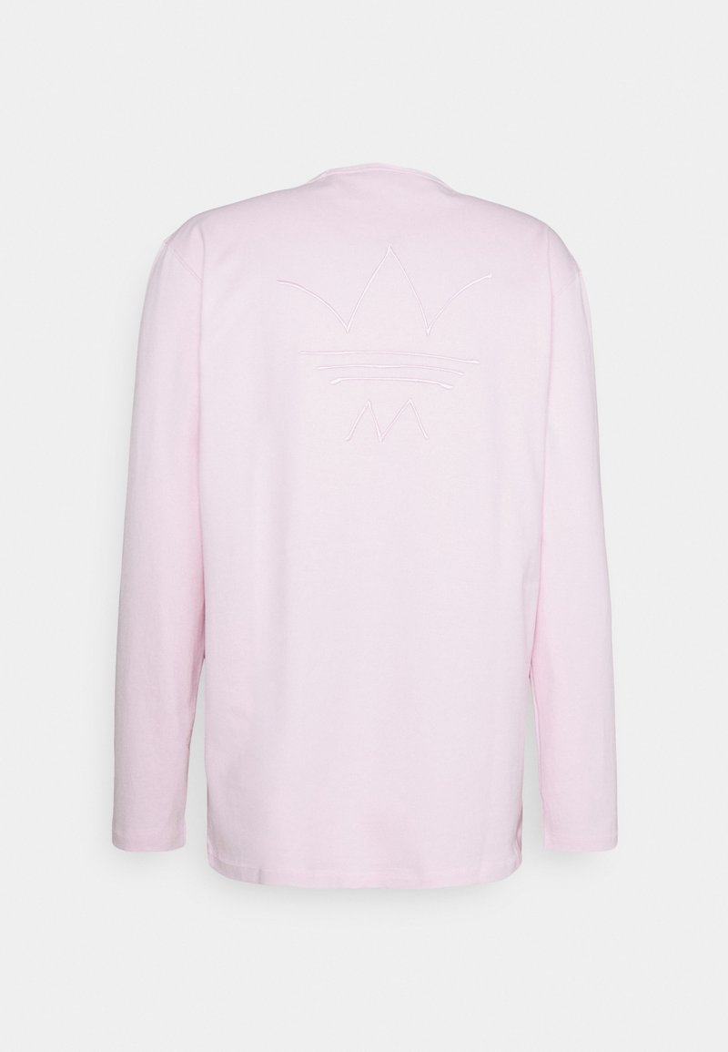 Rosa långärmad t-shirt med rund halsringning, prydd med en texturerad broderad design av en krona och linjer på baksidan.