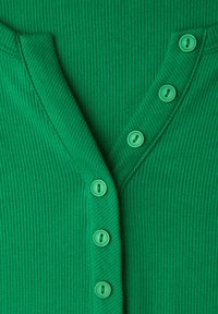 Zielony prążkowany kardigan z dekoltem w serek i sześcioma dopasowanymi zielonymi guzikami na przedniej listwie. Gładka faktura i dopasowany fason.