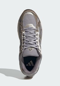 Gray athletic shoe featuring a mesh upper, metallic accents, and a textured sole. Includes gray laces and an Adidas logo on the tongue.