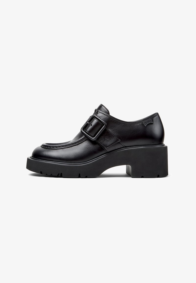 Black leather shoes with a buckle detail, rounded toe, and chunky platform sole. Smooth texture and stitching accents along the upper.