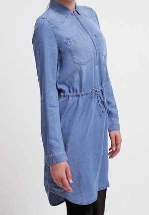 Denim overhemdjurk met lange mouwen, voorrits, twee borstzakken, elastische koord taille en een afgeronde zoom. Lichtblauwe kleur en zachte textuur.