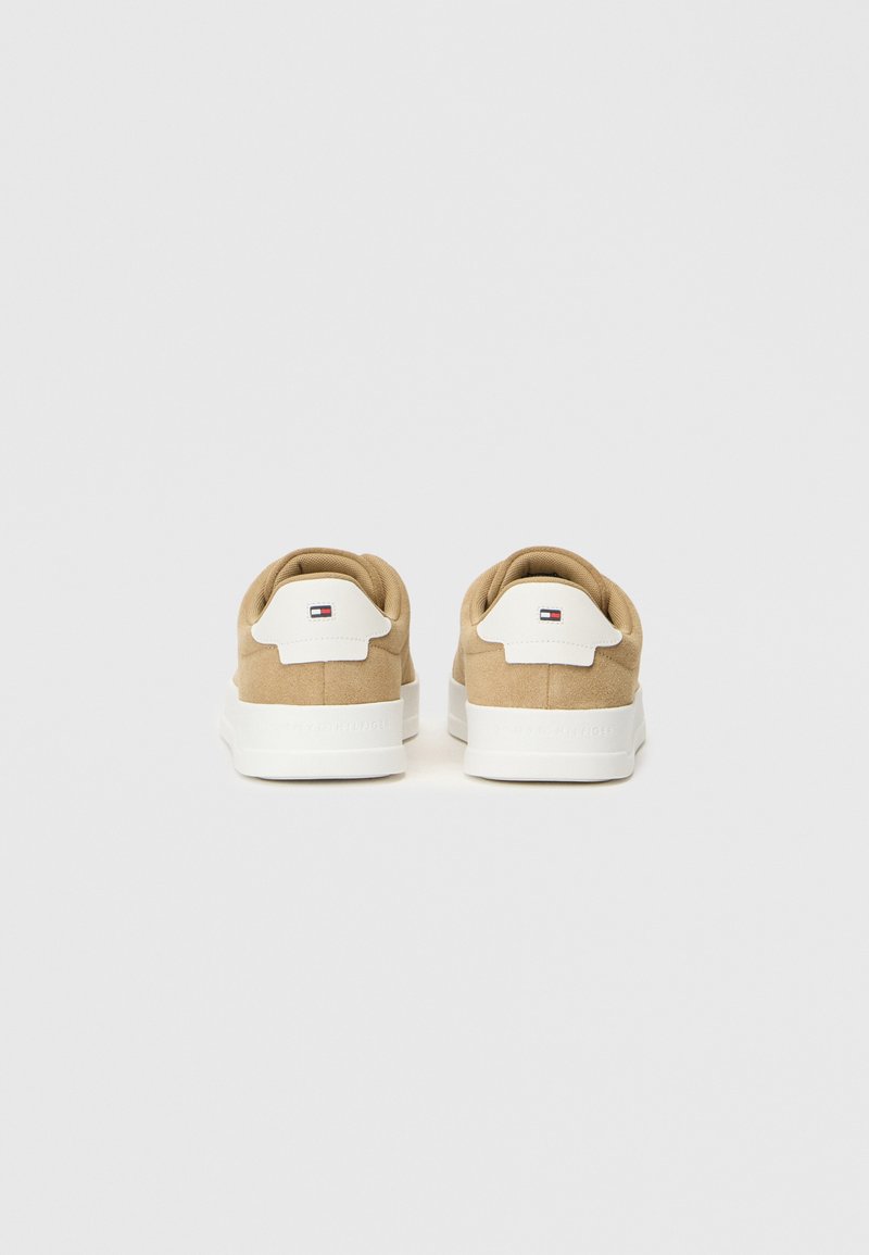 Braune Wildledersneaker mit weißen Gummisohlen, ausgestattet mit einem auffälligen weißen Fersenrand und einem kleinen Logo-Detail auf der Rückseite.