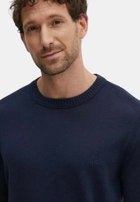 Pull bleu marine  à col rond en tissu doux, avec un col et des poignets côtelés, orné d'un logo BOSS discret sur la poitrine.