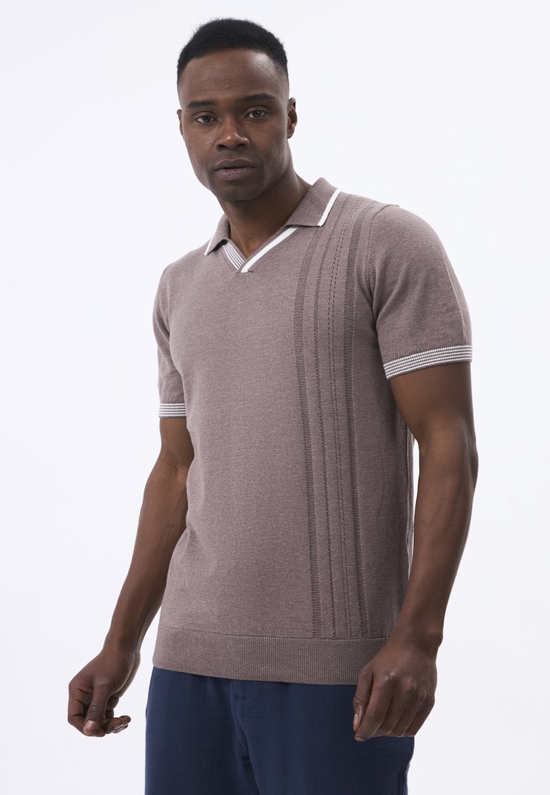 Polo de punto marrón de manga corta con cuello blanco a rayas y detalles de canalé vertical en el frontal. El ajuste es ceñido al cuerpo.