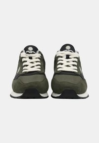 Baskets de sport vertes avec des matériaux en daim et en mesh, présentant des accents noirs, des lacets blancs et une épaisse semelle en caoutchouc noir.