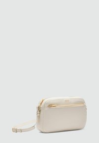 Cremefarbener Leder-Crossbody-Beutel mit goldenen Beschlägen, rechteckiger Form, flacher Fronttasche, verstellbarem Schultergurt und geprägtem Logo.